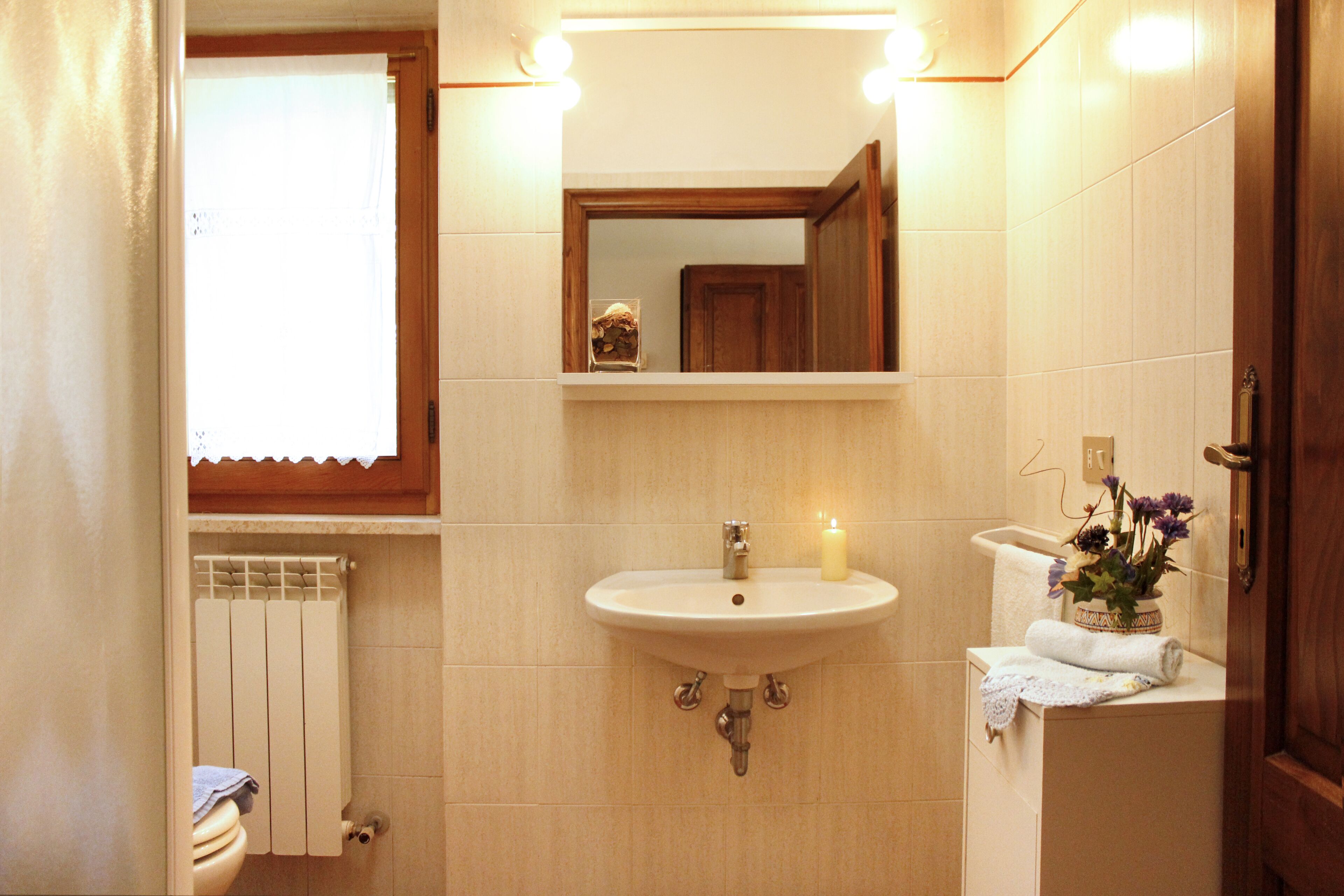 Une salle de bain avec un lavabo, un miroir et des toilettes.