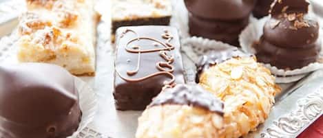 Una variedad de postres, incluyendo bombones de chocolate y pastelería, sobre una bandeja.