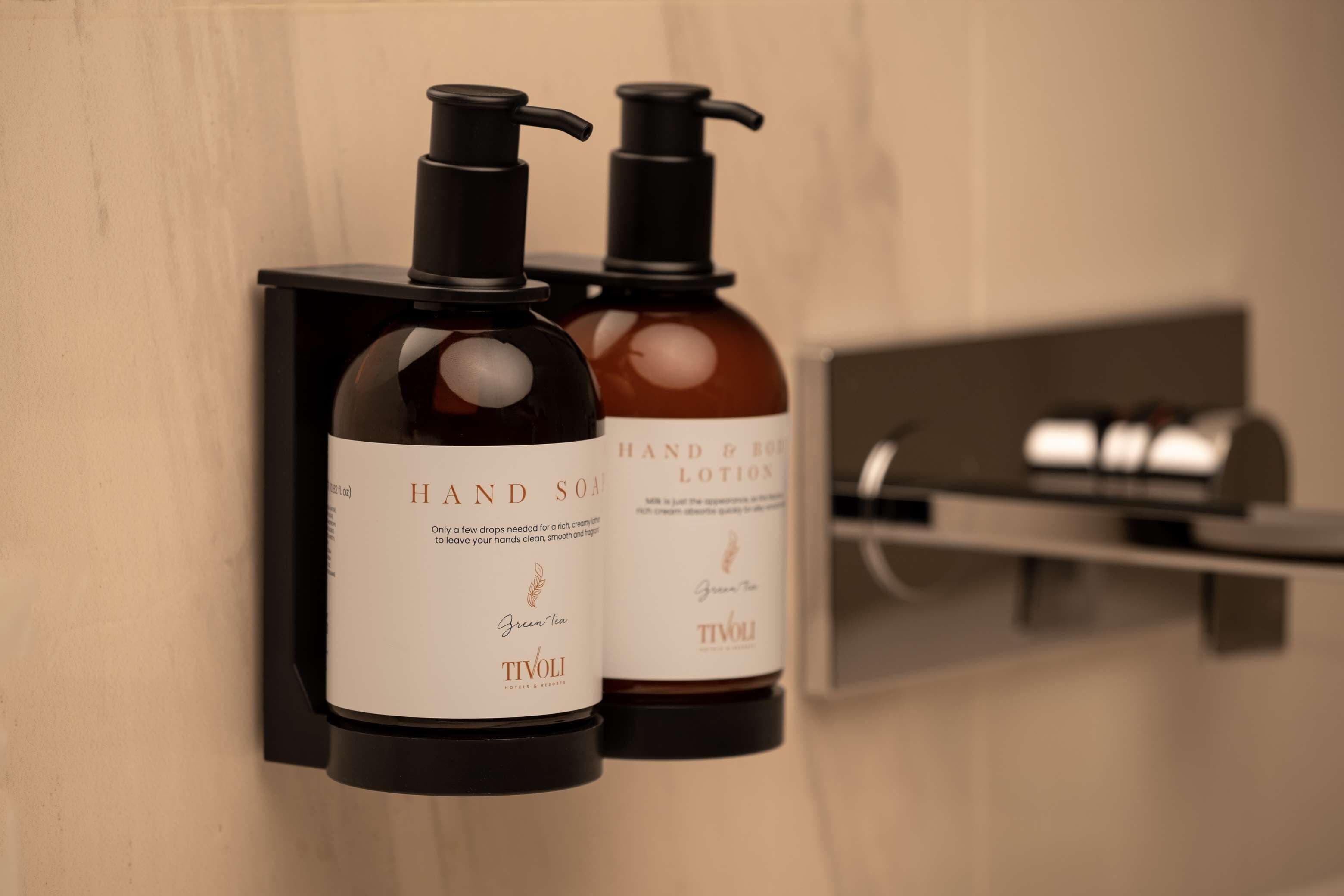 Two hand soap dispensers mounted on a wall, one labeled 'HAND SOAP' and the other 'HAND & BODY LOTION.'