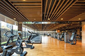 A gym with exercise equipment, wooden flooring, and large windows. - Lvdao International Hotel (Quanzhou)
