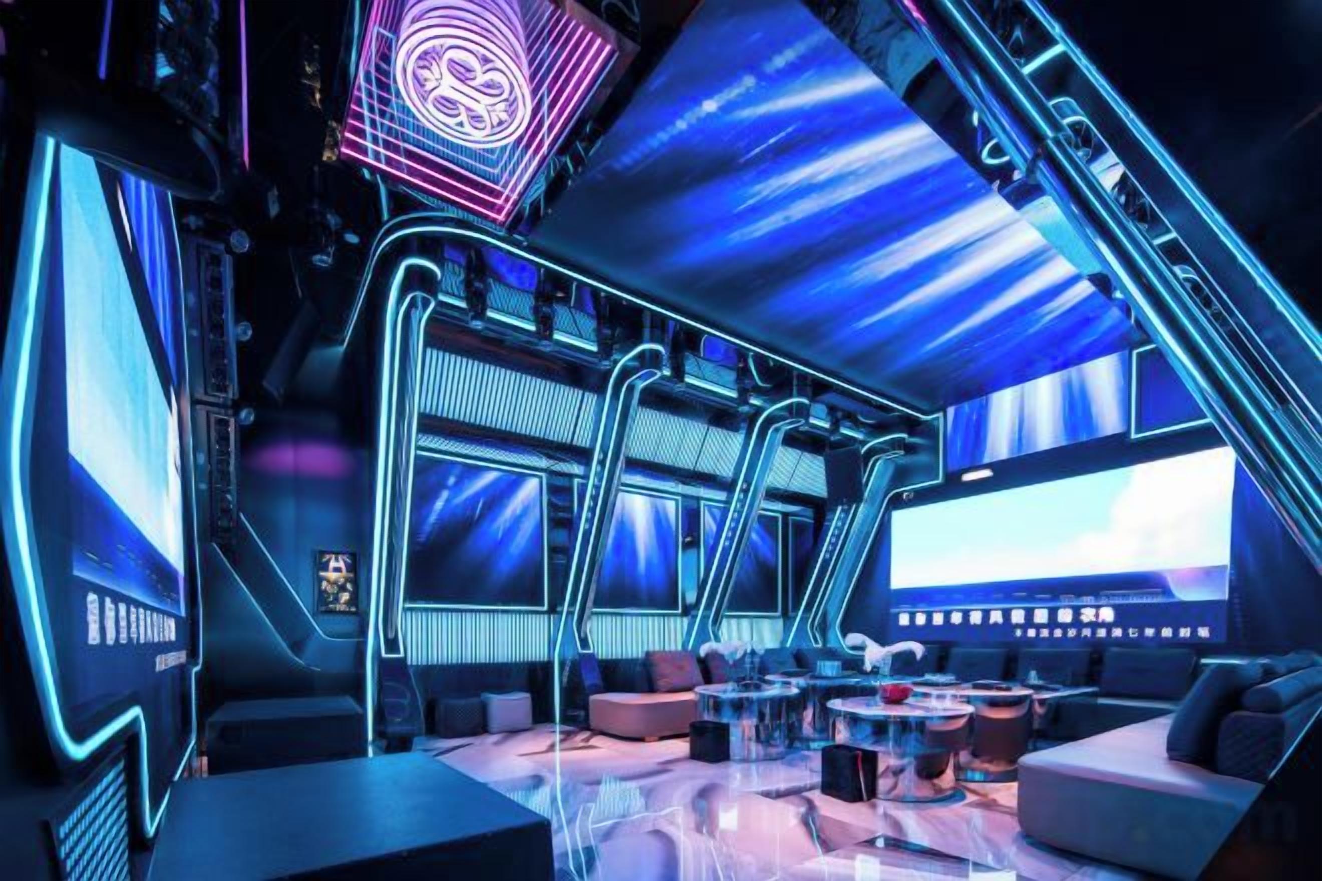Un salón futurista con techo curvo, pantallas grandes y asientos modernos.