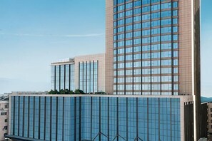Un edificio moderno con ventanas de vidrio reflectante, techo plano y una estructura vertical destacada.