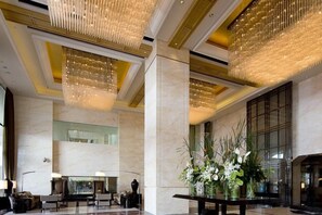 A spacious lobby with a high ceiling, chandeliers, marble flooring, and a seating area. - Lvdao International Hotel (Quanzhou)