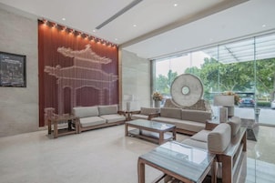 Un vestíbulo moderno con área de descanso, una pared decorativa y un ventanal grande.