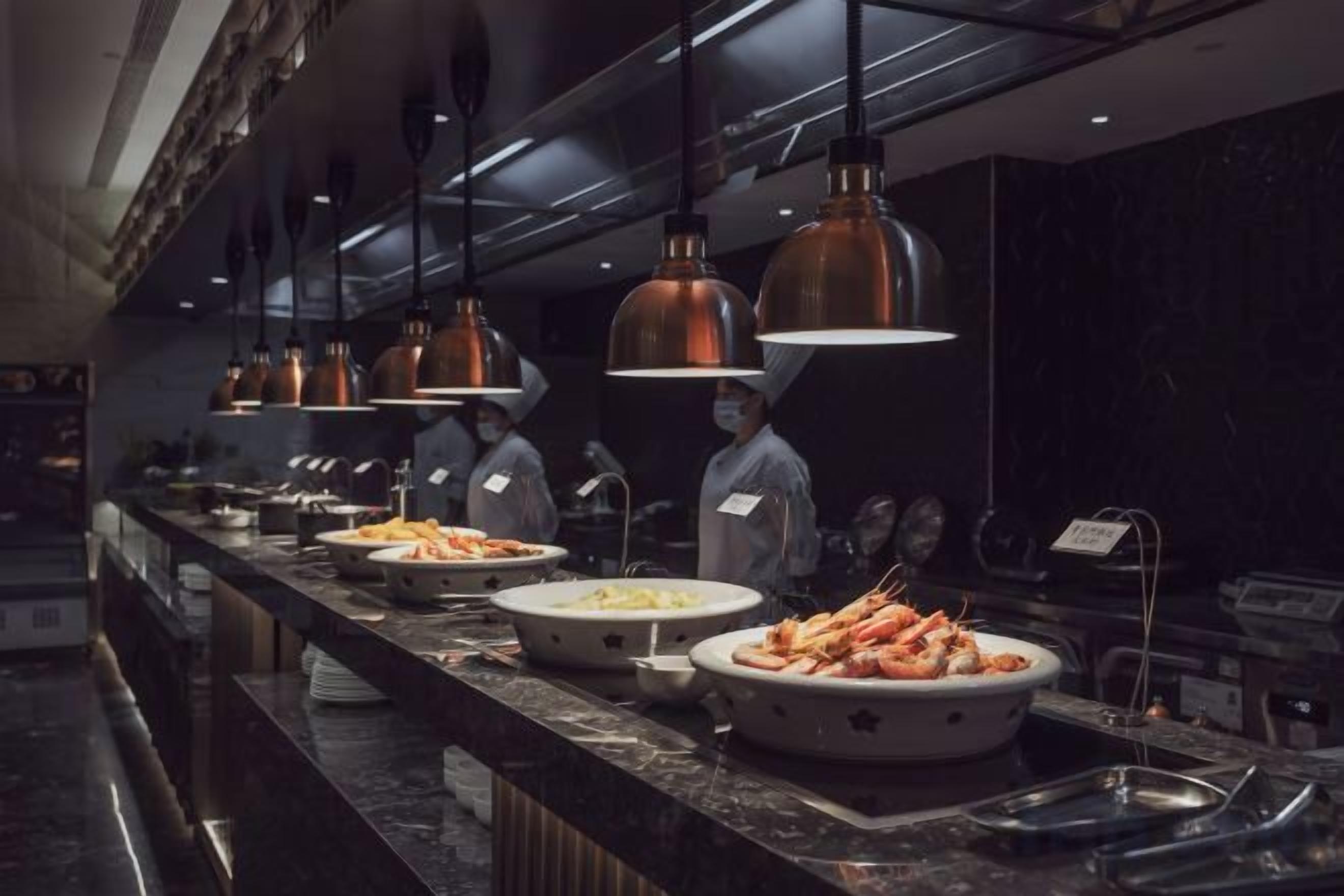 En buffet med flere retter og en lang bænk.