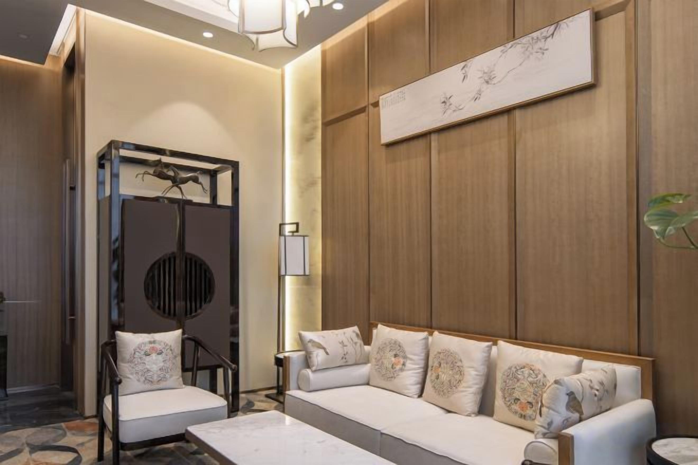 A modern interior with a sofa, chairs, and a decorative wall piece.