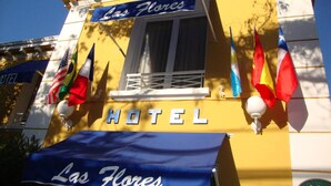 Hotel Las Flores, con un toldo azul y varias banderas a la vista.