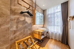 Une salle de bain moderne avec un meuble-lavabo en bois, un grand miroir et un porte-serviettes suspendu.