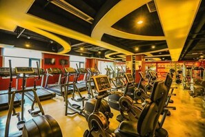 Academia com esteiras, elípticos e equipamentos de musculação.