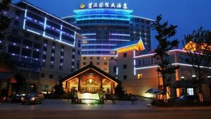 A hotel with a modern design, featuring a prominent entrance and multiple floors with illuminated signage. - Cangxi International Hotel (Cangxi)