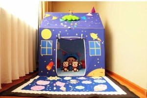 Una casita de juegos con un tobogán, dos osos de peluche en su interior y un tema de noche estrellada.