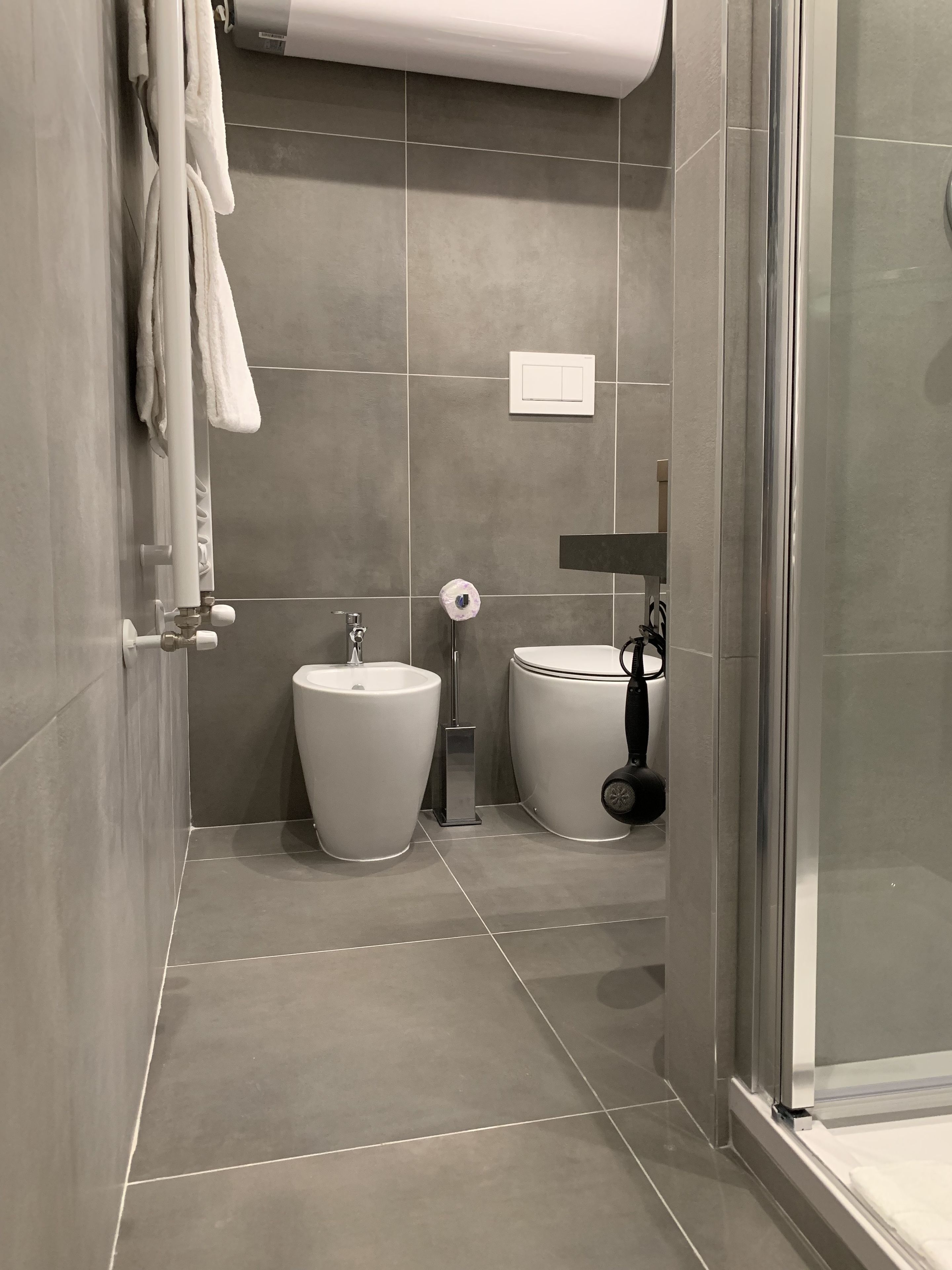 A modern bathroom with a toilet, bidet, and sink.