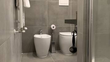 A modern bathroom with a toilet, bidet, and sink.