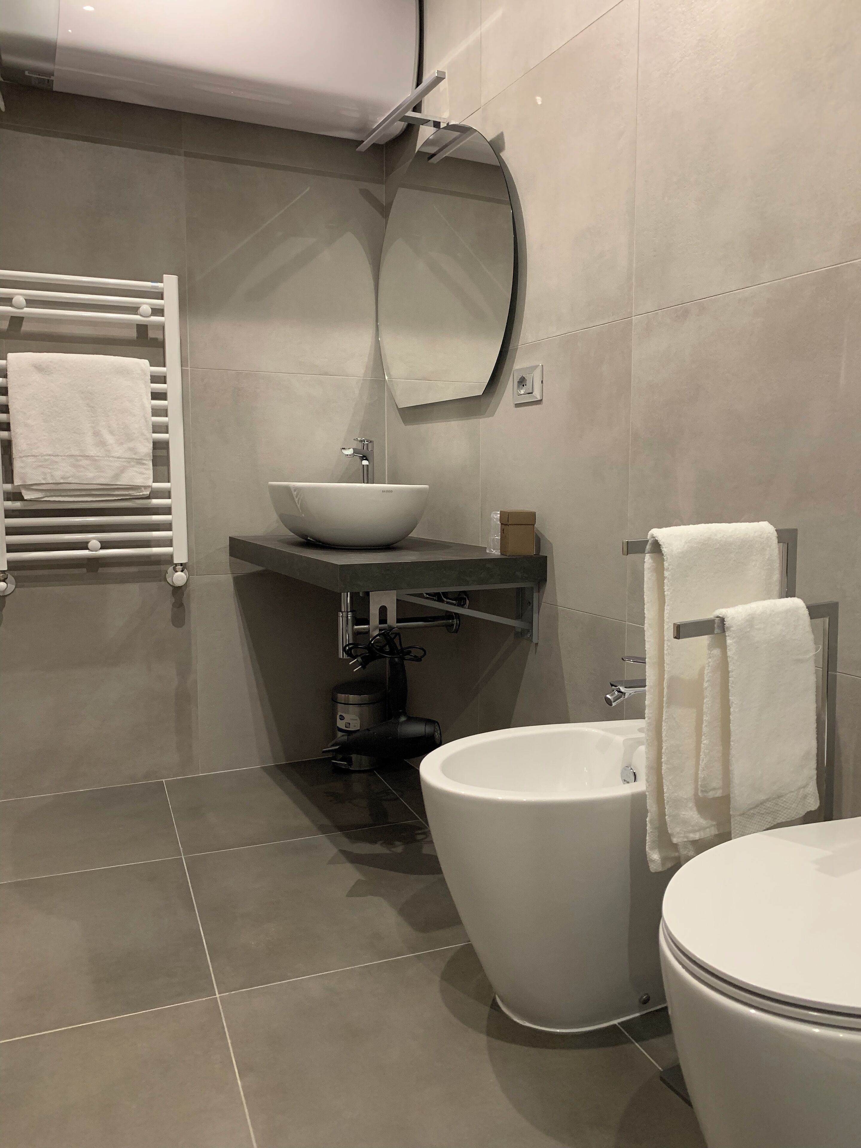 Une salle de bain moderne avec un lavabo sur colonne, des toilettes et un bidet.