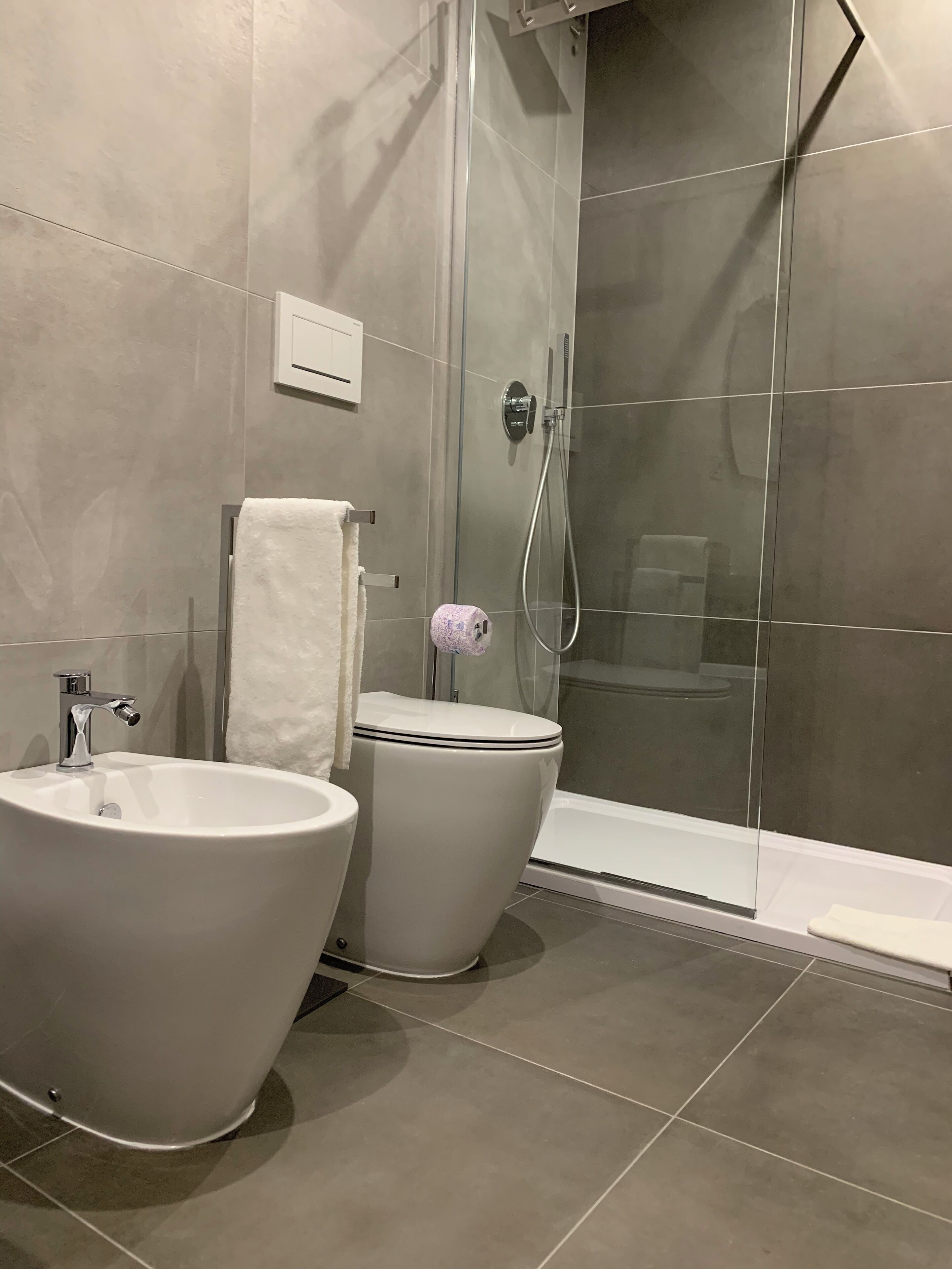 Ein modernes Badezimmer mit einer freistehenden Badewanne, einer Toilette und einer behindertzugänglichen Dusche.