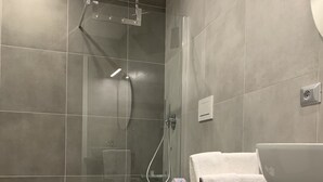 A modern bathroom with a glass-enclosed shower, a white toilet, and a large sink with a mirror. - ApartHotel Bossi (Milan)