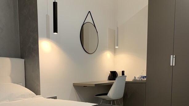A modern bedroom with a large bed, a desk, and a wardrobe. - ApartHotel Bossi (Milan)