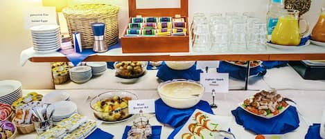 Montaje de bufé con diversas opciones de comida y bebidas.