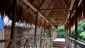 A wooden structure with a thatched roof and a wooden walkway leading to a building.