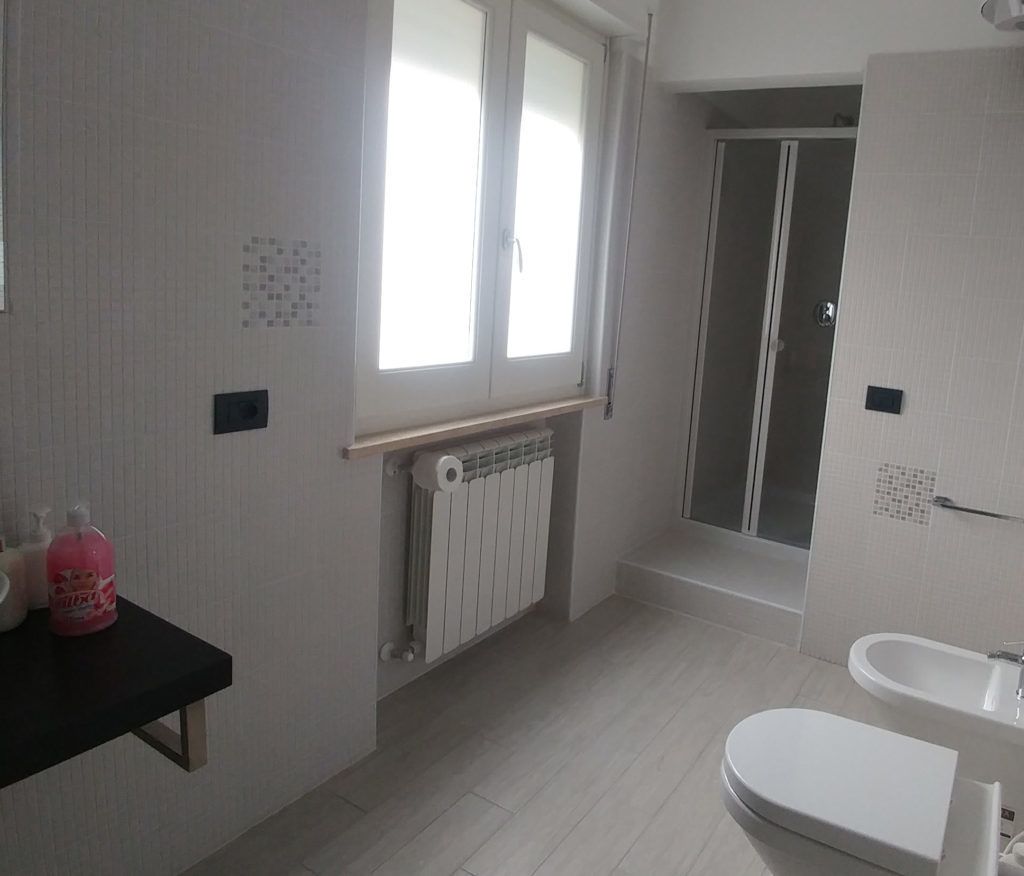 Une salle de bain avec des toilettes, un lavabo et une douche.