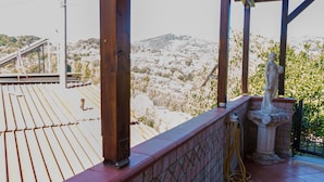 A terrace with a tiled floor, a statue, and a view of a hilly landscape. - B&B Villa Bella (Catanzaro)