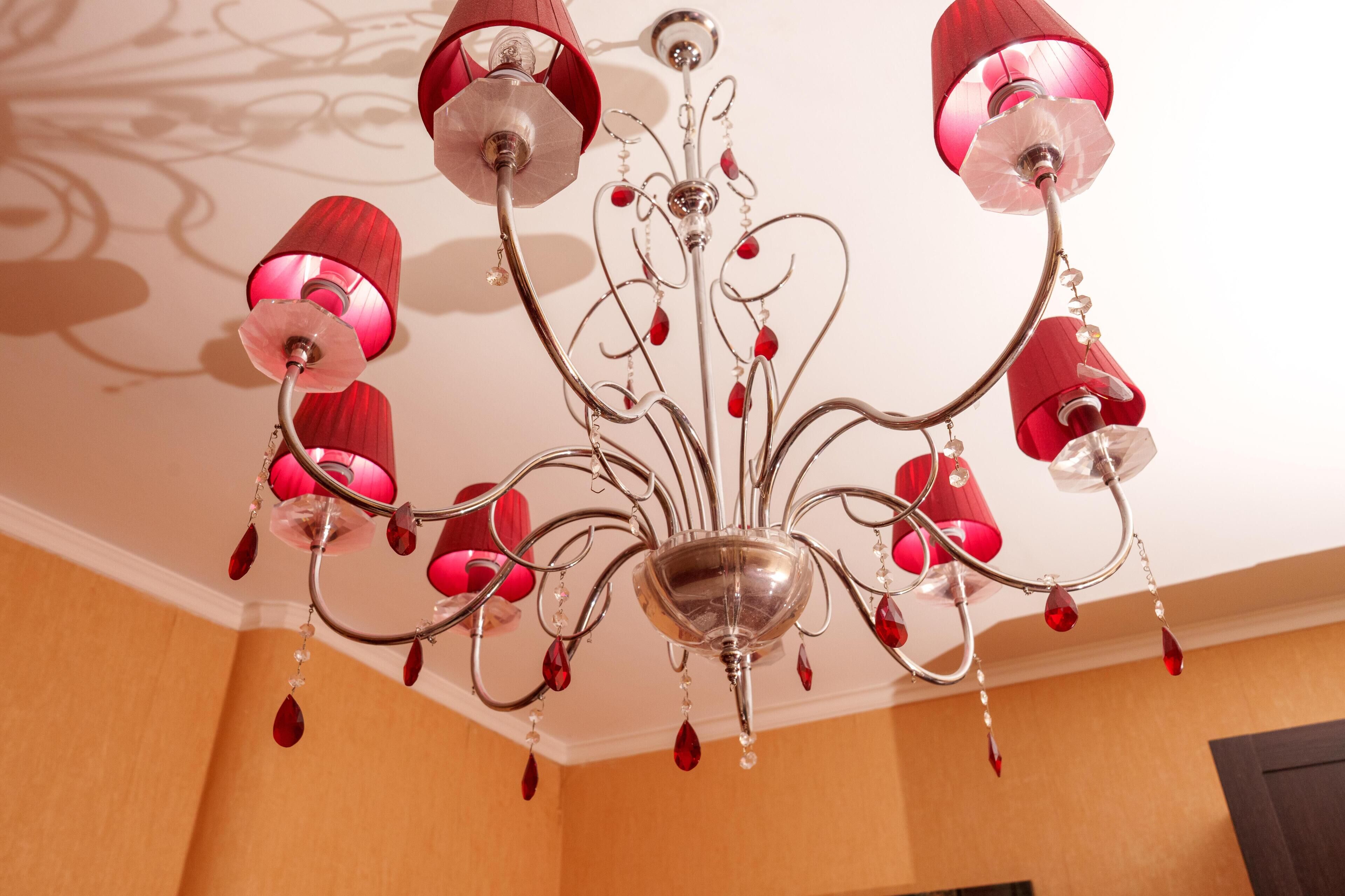 A chandelier with multiple arms and red glass shades.