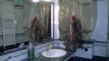A bathroom with two sinks, a mirror, and a towel rack.