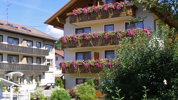 A multi-story building with balconies, some with flower boxes. - Hotel garni Schmideler (Sonthofen)