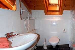 Un baño con lavamanos blanco, inodoro y ducha.