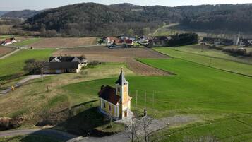 A rural landscape with a church, houses, and fields.