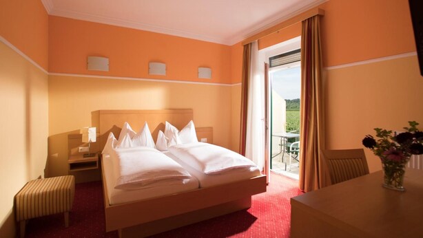 Une chambre d’hôtel équipée d’un lit, d’un bureau, d’une chaise et offrant une vue sur l’extérieur.