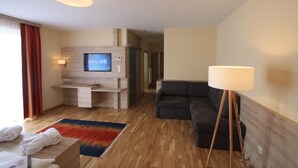 Une chambre d’hôtel moderne équipée d’une télévision, d’un canapé et d’une lampe.