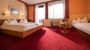 A hotel room with a bed, a desk, a chair, and a window with curtains. - Hotel Restaurant Schachenwald (Premstätten)