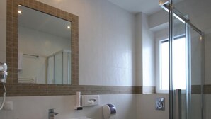 A bathroom with a sink, mirror, toilet, and glass shower enclosure. - Hotel Restaurant Schachenwald (Premstätten)