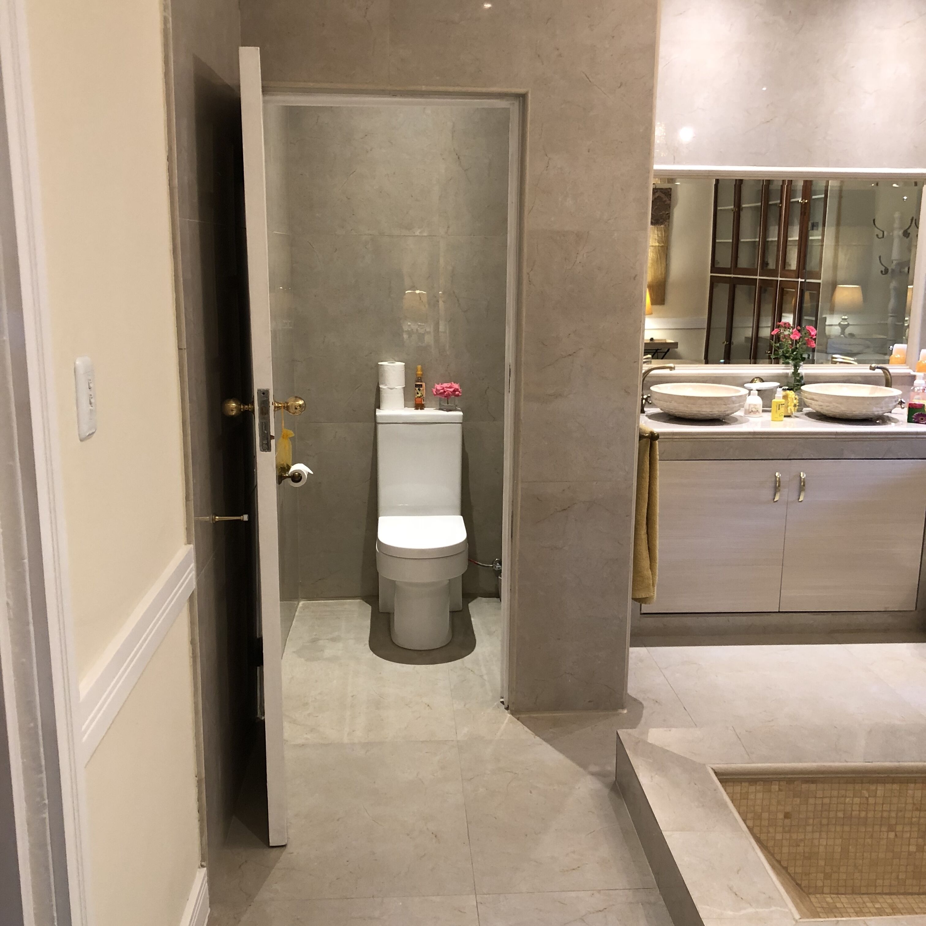 A modern bathroom with a toilet, bidet, and two sinks.
