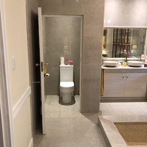 A modern bathroom with a toilet, bidet, and two sinks.