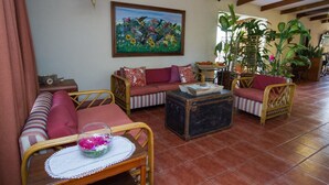 A cozy living room with a sofa, chairs, a coffee table, and a painting on the wall. - Hotel y Desayuno Colibri (Managua)