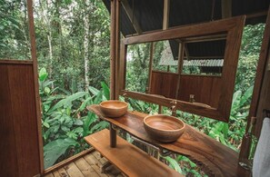 A wooden bathroom with a large window, two wooden bowls, and a bench. - La Manigua Lodge (La Macarena)