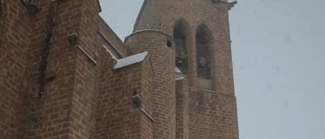 Un edificio de ladrillo con una amplia entrada en arco y una torre alta.
