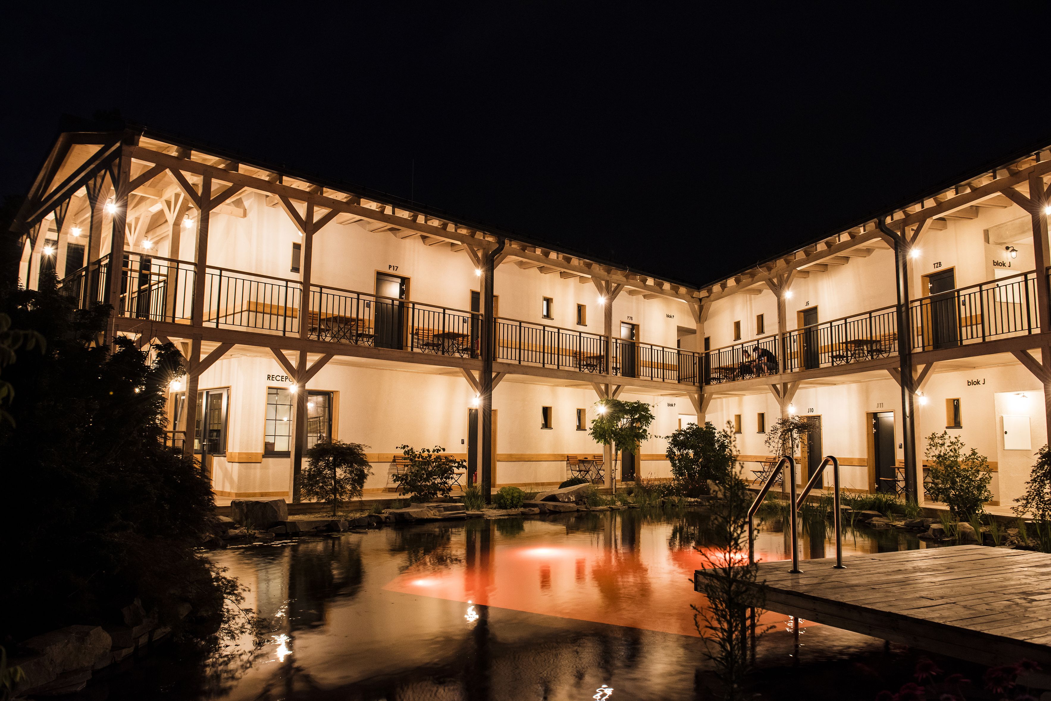 A multi-story hotel with a courtyard and a reflecting pool.