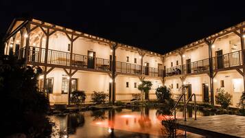 A multi-story hotel with a courtyard and a reflecting pool.