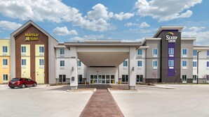 A hotel with MainStay Suites and Sleep Inn branding, featuring a central entrance with a covered walkway. - Sleep Inn Lancaster Dallas South (Lancaster)