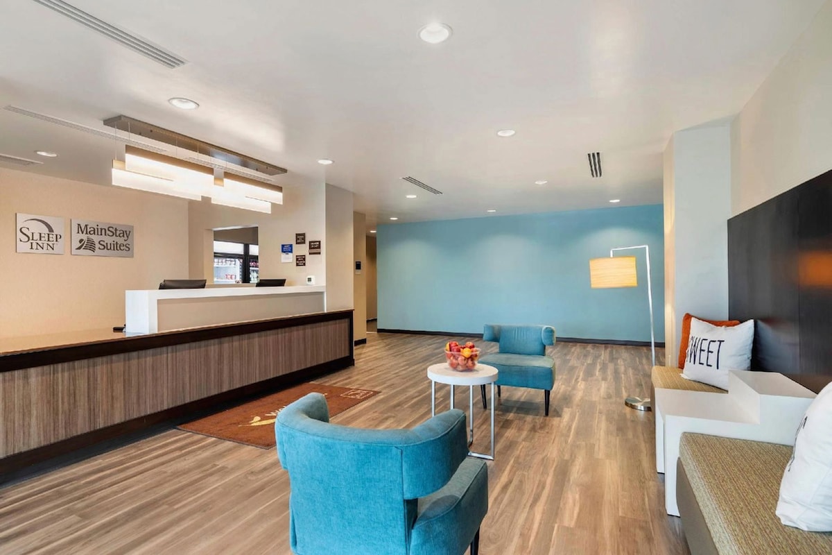A hotel lobby with a reception desk, seating area, and a wall-mounted sign.