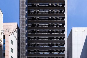 A high-rise building with multiple balconies and a modern architectural design.