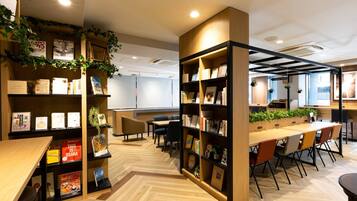 Una biblioteca moderna con estanterías de madera, una mesa larga y sillas.