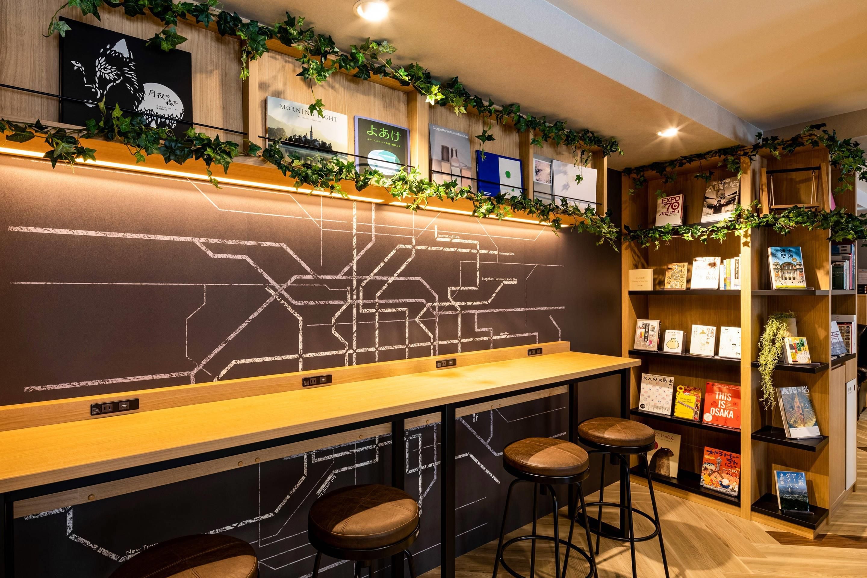Una zona de bar con taburetes, una barra y una pared con un diseño geométrico.