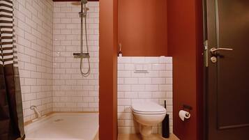 A bathroom with a bathtub, toilet, and shower.