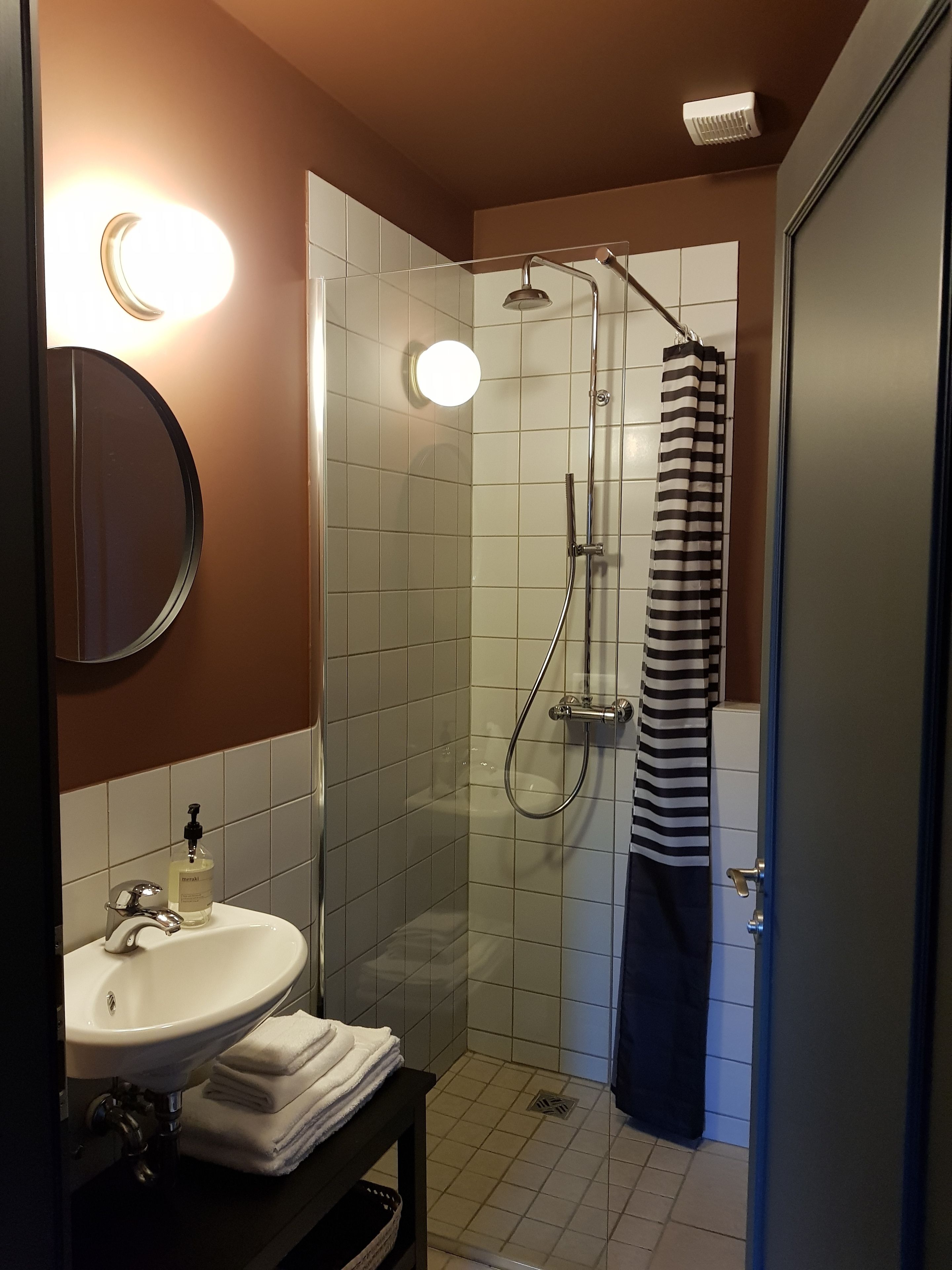 Un baño con lavamanos, espejo y ducha.