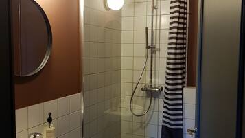 Un baño con lavamanos, espejo y ducha.