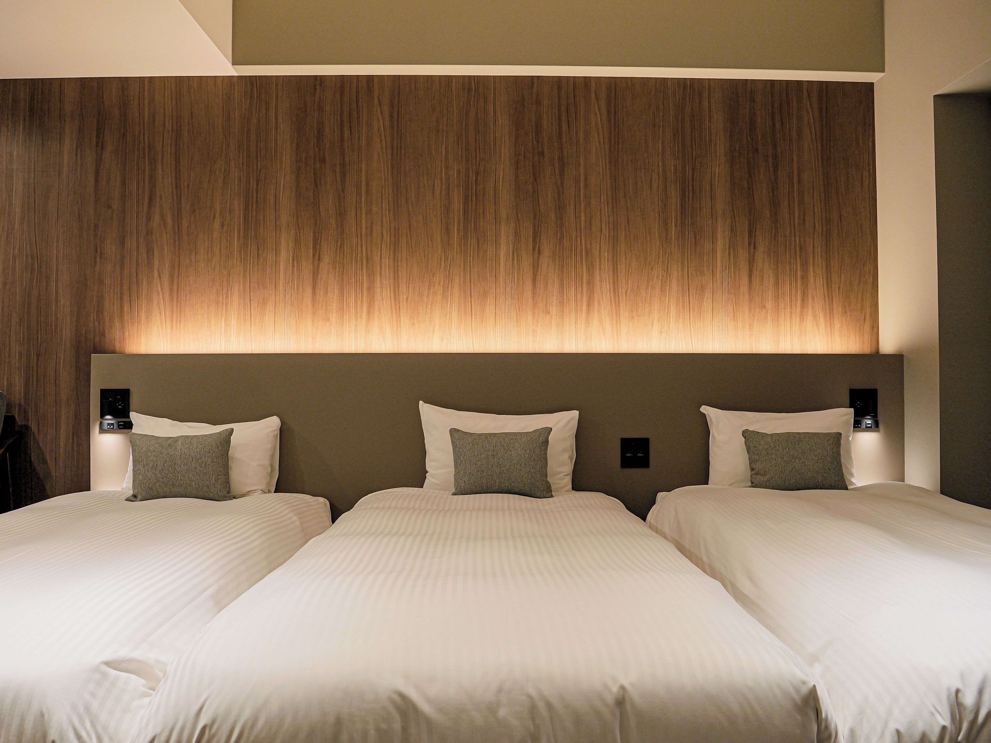 A hotel room with a large bed, two bedside tables, and a wooden headboard.